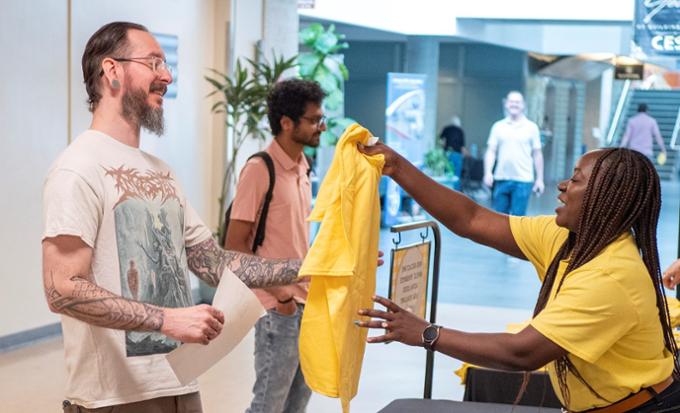 A man receiving a t-shirt from a woman