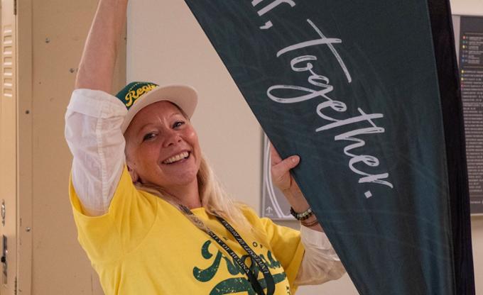 A woman adjusting a flag banner