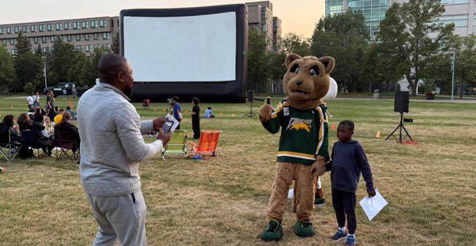 U of R mascot poses with young person