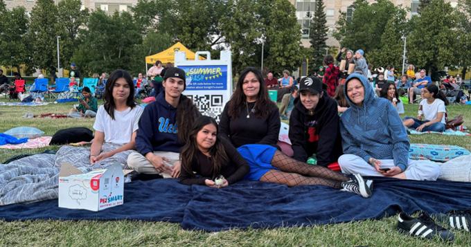 group of people sitting on a blanket