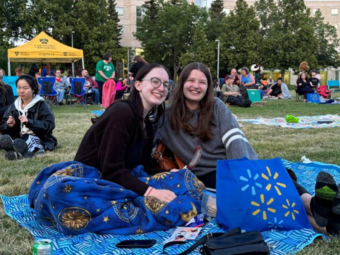 two people sitting on a blanket