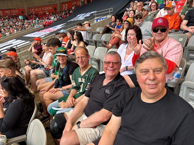 four people sitting in the stands