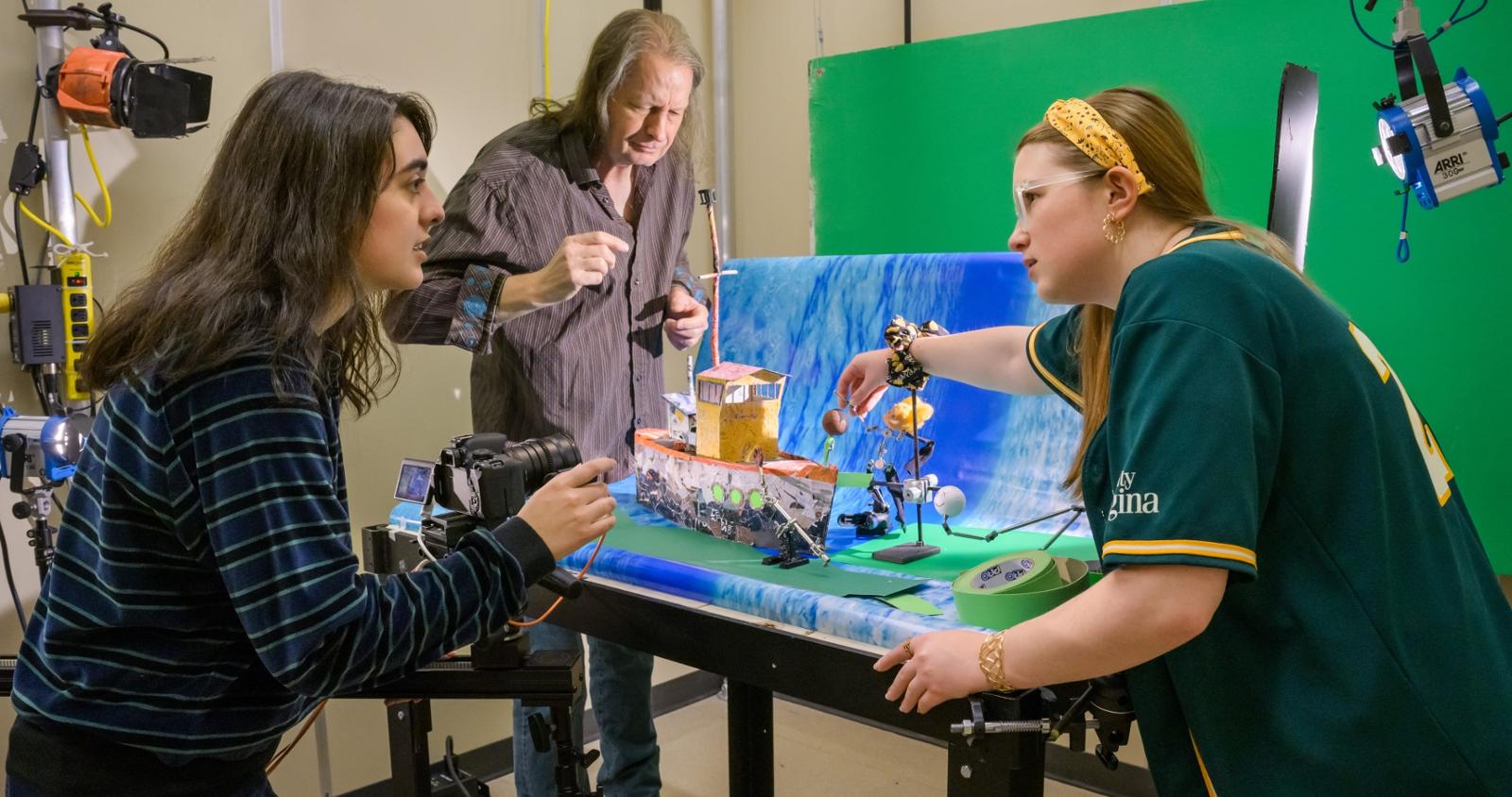 Three people working on a diorama