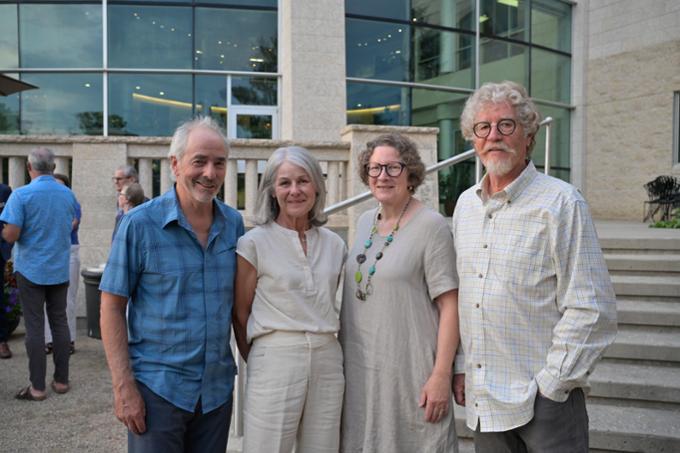 Four people stand outdoors.