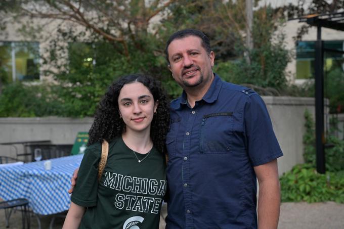 Man and young woman standing outdoors.