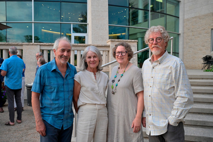 Four people standing outside looking at camera.