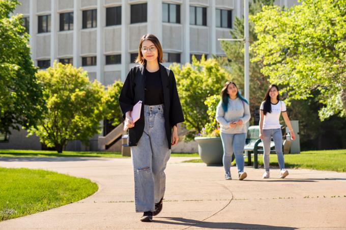 student holding a book and walking