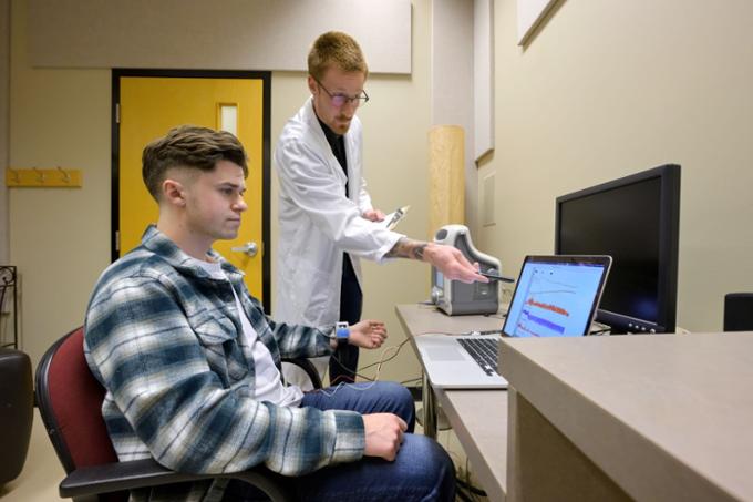 Psychology student participating in a research study by monitoring heart rate.