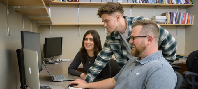 Three students working together on a computer