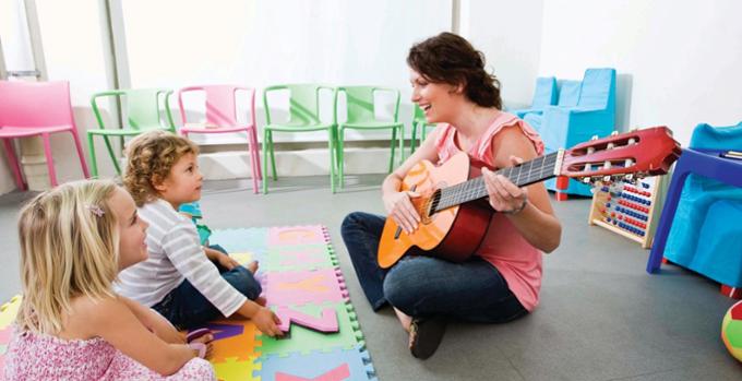 An instructor and two students learning guitar