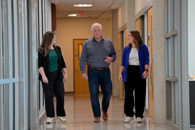 Hannah, Bruce and Ashley walking down a hallway