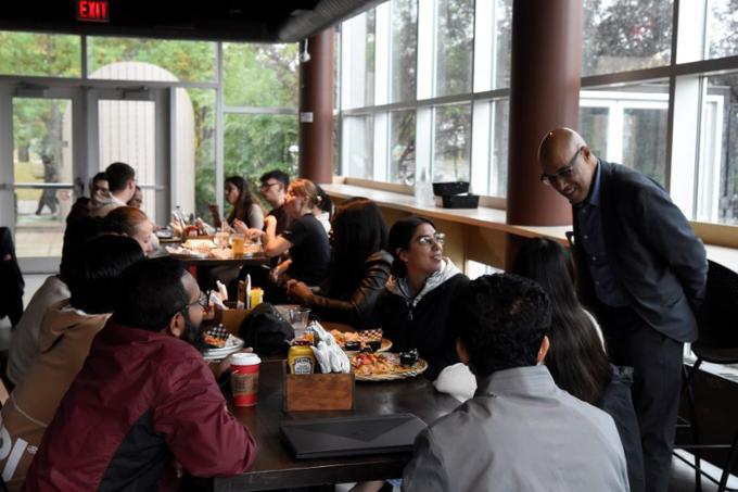 Dr. Aziz Douai interacting with students over nachos