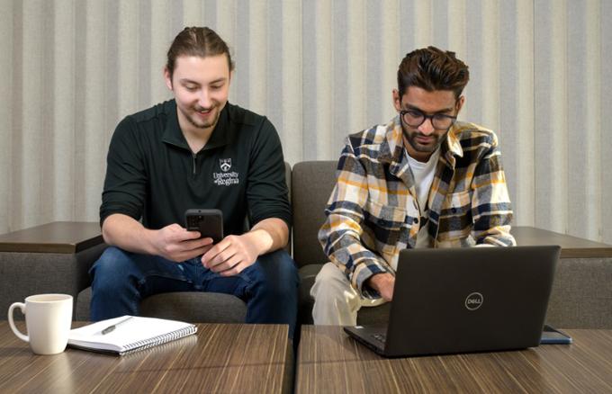 students scrolling laptop