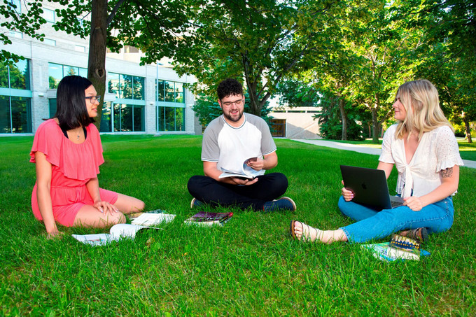 students sitting on ground and having conversation