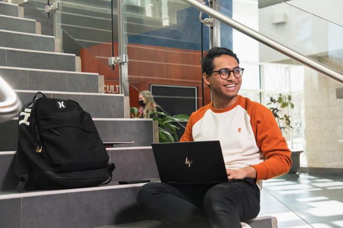 A person sitting on stairs with a laptop