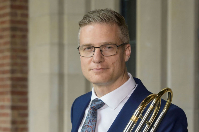 A man standing with a trombone