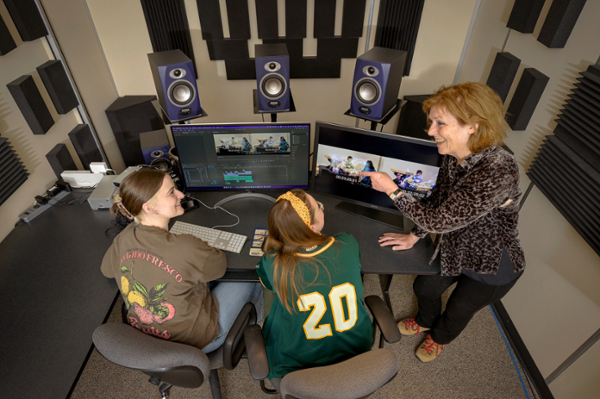 Two students and a faculty member in the editing booth