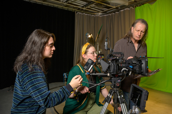 three people shooting on a camera