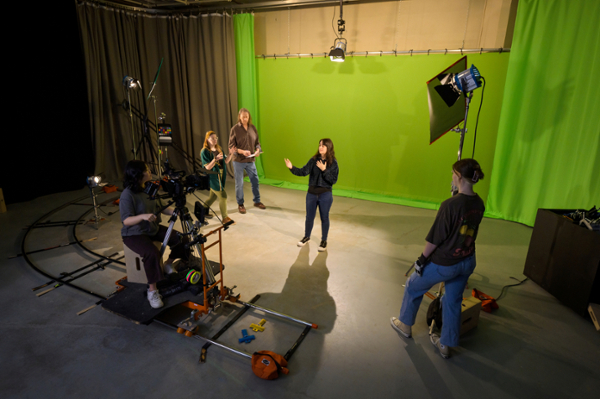 Students filming in a green room