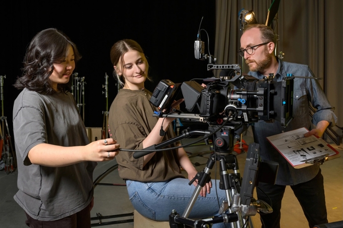 Students using camera with department head