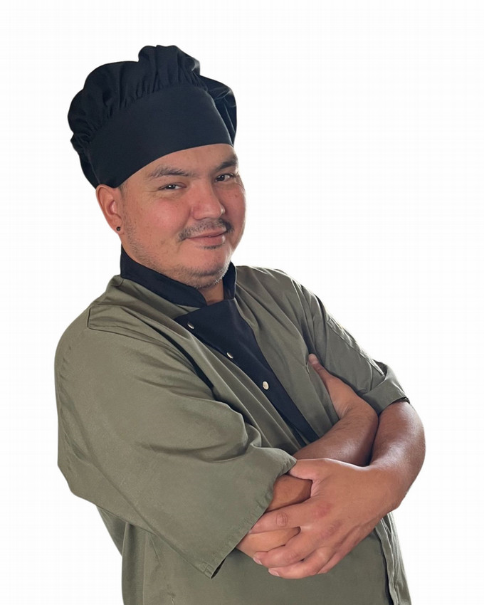 a smiling man wearing a chef's hat