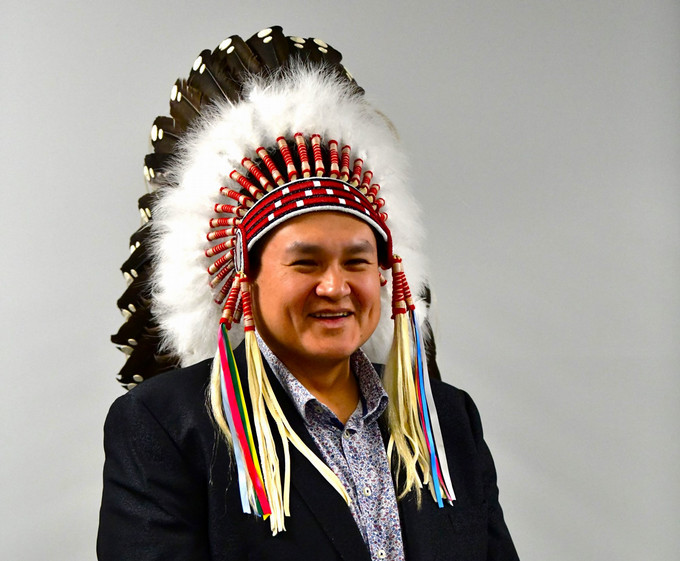 A smiling man wearing a headdress