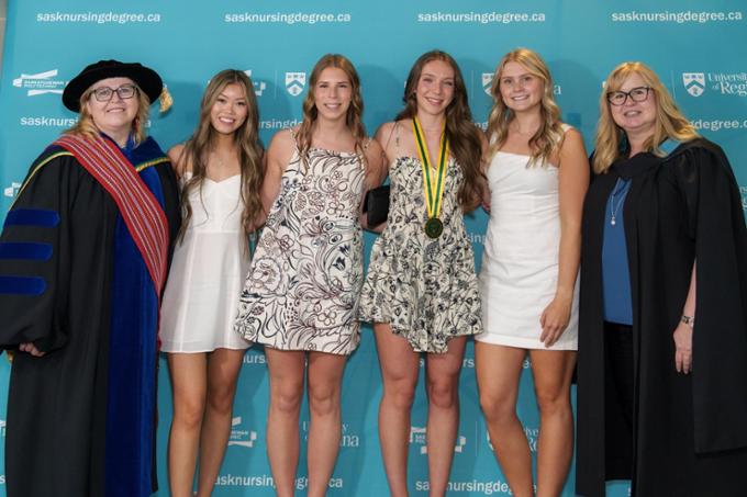 nursing graduates posing for a photo with the nursing deans