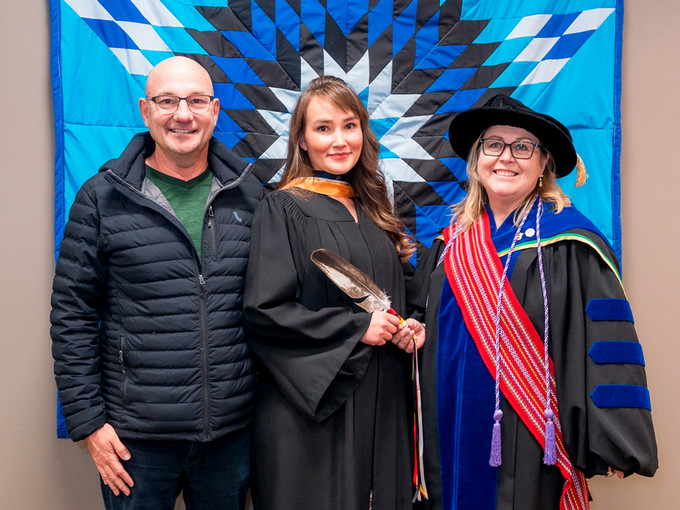 nursing graduate with family and dean