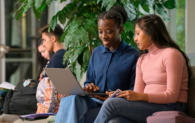 two student sitting and working on a laptop together