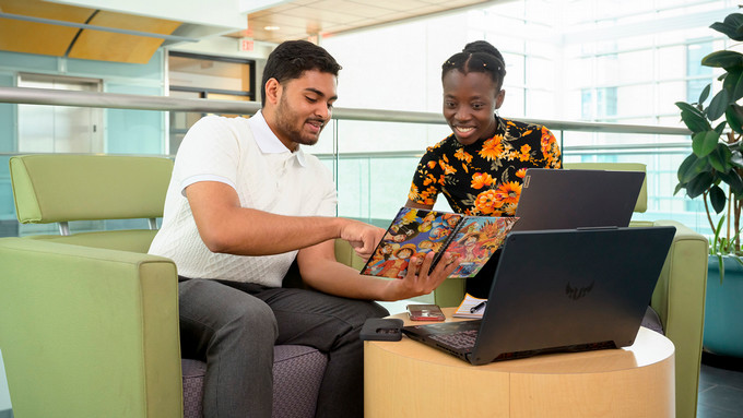 two students working on a laptop together