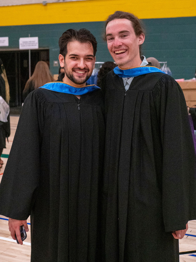 two students in convocation gowns