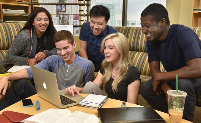 Five students looking at a laptop screen