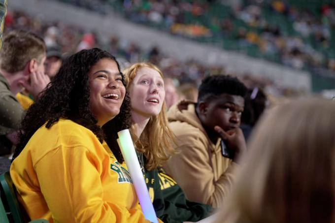 Three students cheering on the Cougars