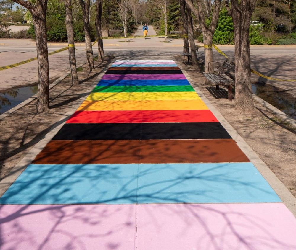 A sidewalk painted with the colours of the rainbow