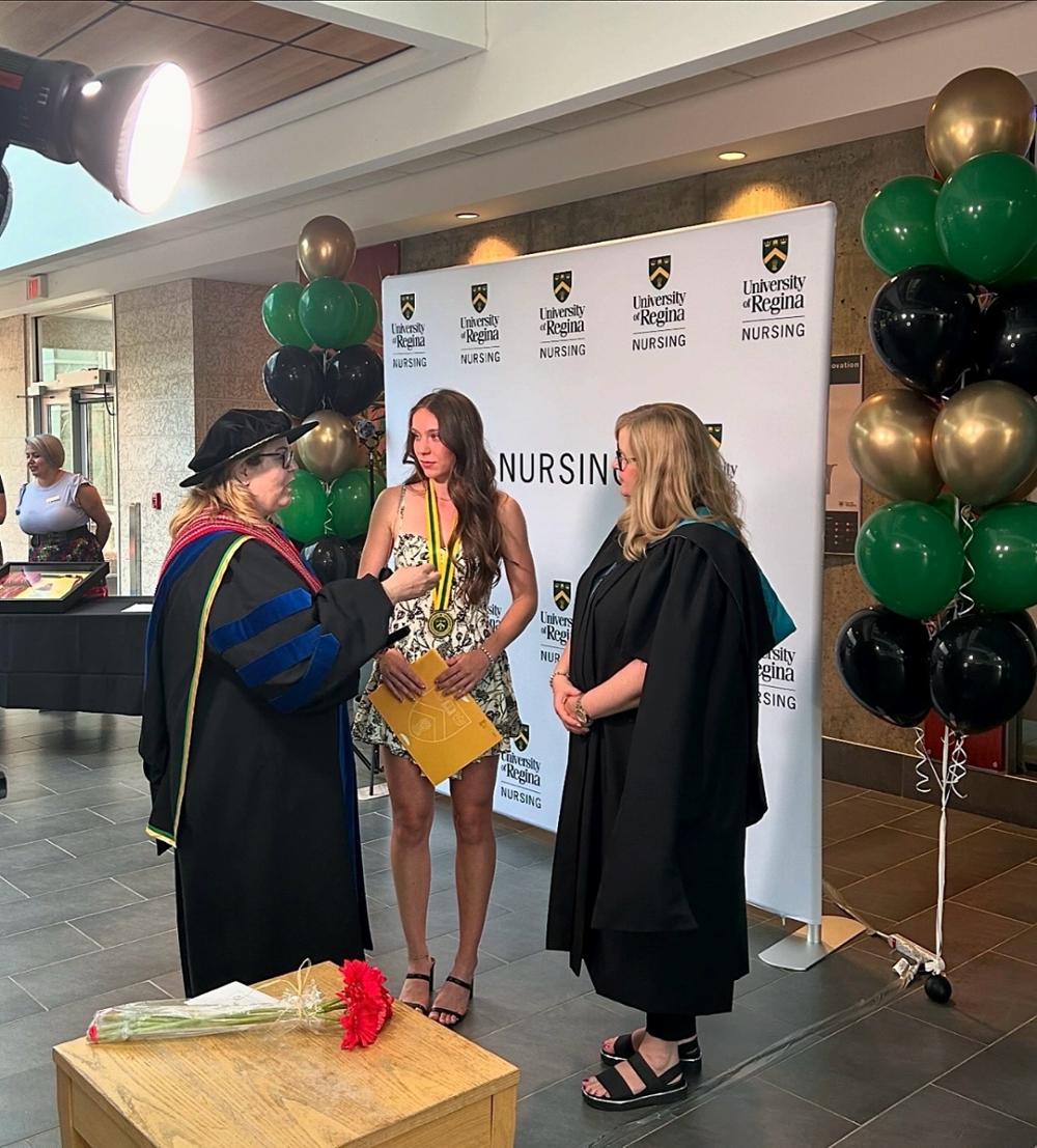 Three individuals talking with each other at a Faculty of Nursing event.