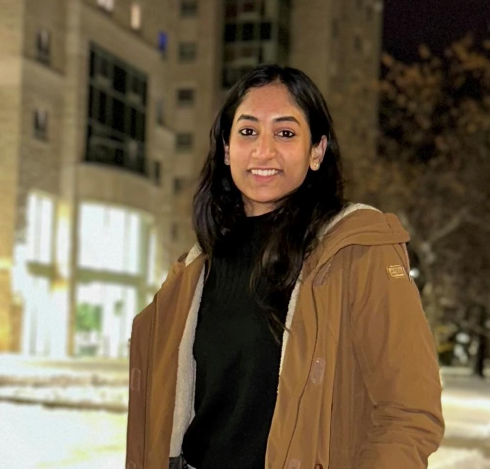 Alt text – A woman stands outside a building.