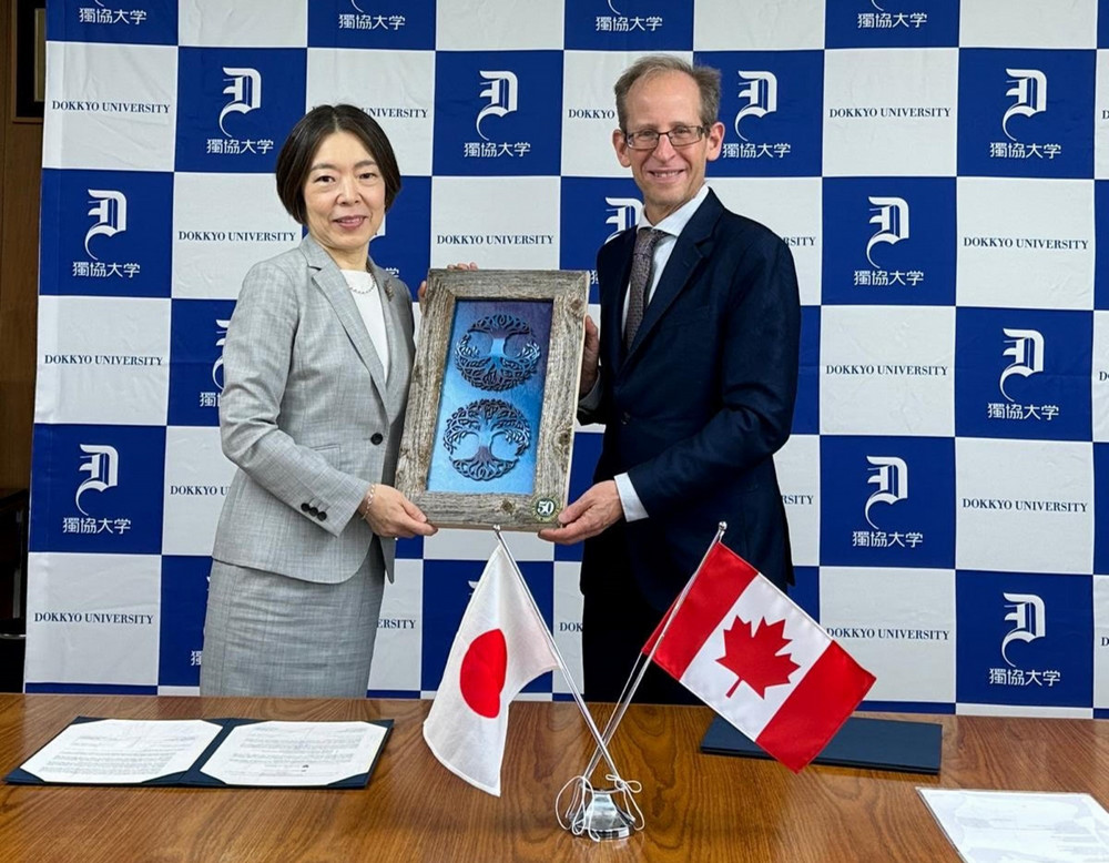 two people holding a framed piece of art