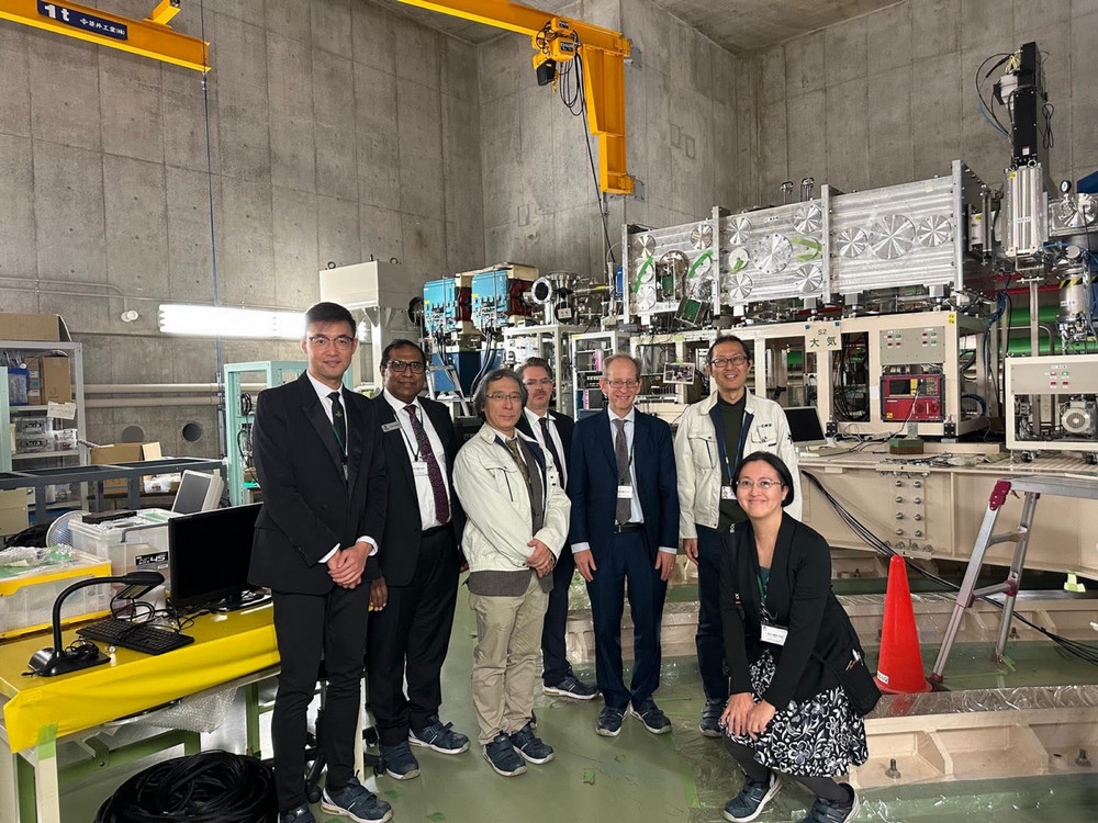 seven people pose in a nuclear science lab