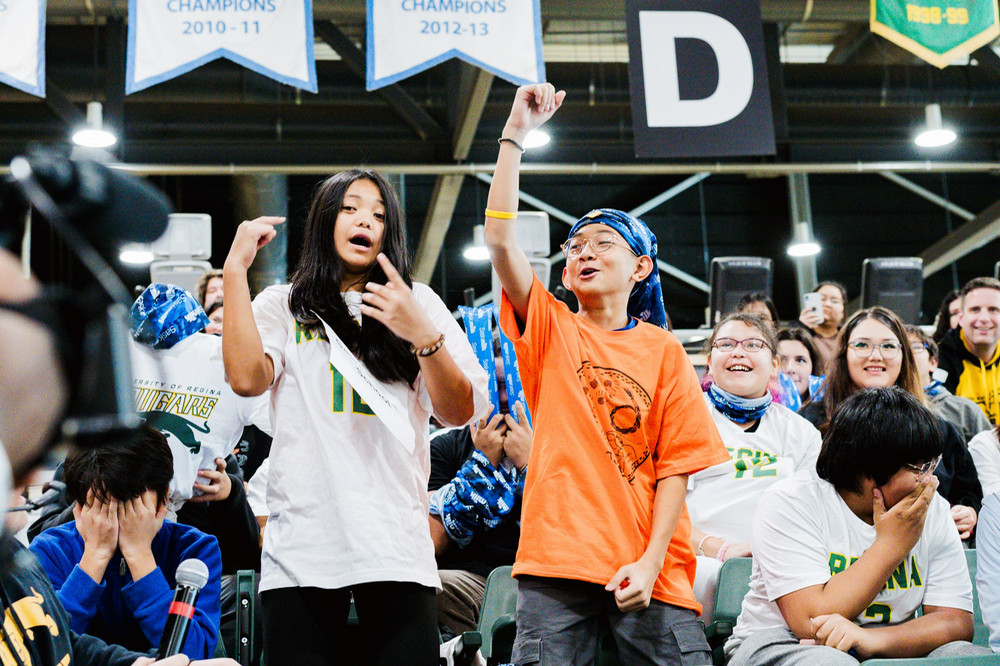 Students cheering at a women’s university basketball game