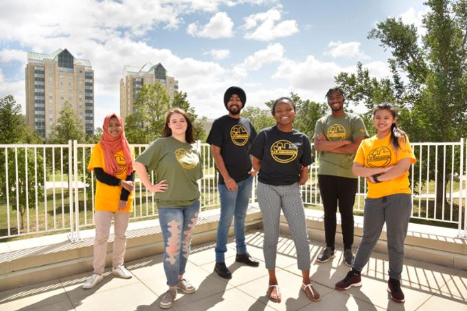 Four students standing outside on campus