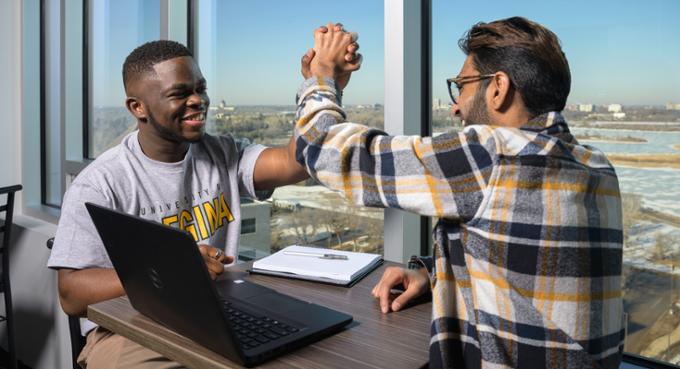 Two students high fiving.