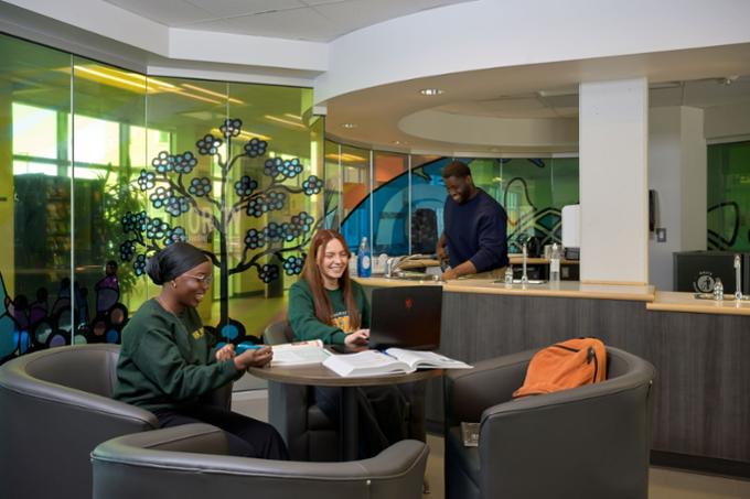 Three students sitting in housing lounge.