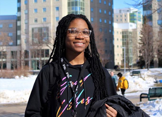 Girl standing outside in front of towers smiling.