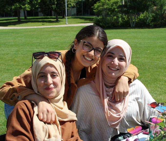 Three female students sitting outside