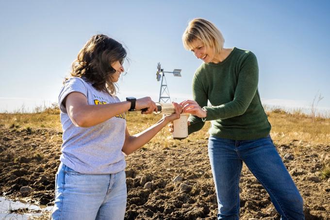 Student and faculty member doing research in a field.