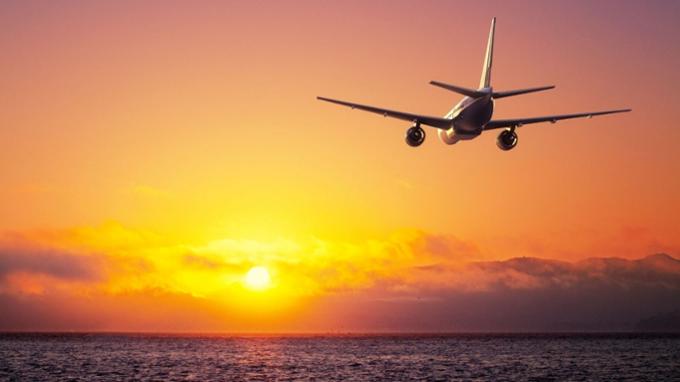 Plane flying at sunset.