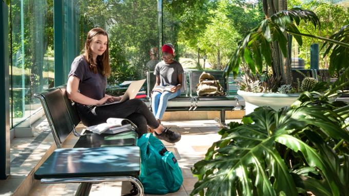 Students sitting in glass atrium